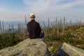 Young man tourist sittiing on top of mountain, Sumava National Park and Bavarian Forest, Czech republic and Germany Royalty Free Stock Photo