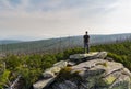 Young man tourist sittiing on top of rock, Sumava National Park and Bavarian Forest, Czech republic and Germany Royalty Free Stock Photo