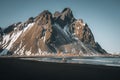 Young man tourist standing at beach during sunset runrise and gorgeous reflection of Vestrahorn mountain on Stokksnes Royalty Free Stock Photo