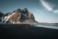 Young man tourist standing at beach during sunset runrise and gorgeous reflection of Vestrahorn mountain on Stokksnes Royalty Free Stock Photo