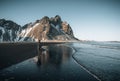 Young man tourist standing at beach during sunset runrise and gorgeous reflection of Vestrahorn mountain on Stokksnes Royalty Free Stock Photo