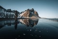 Young man tourist standing at beach during sunset runrise and gorgeous reflection of Vestrahorn mountain on Stokksnes Royalty Free Stock Photo