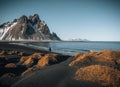 Young man tourist standing at beach during sunset runrise and gorgeous reflection of Vestrahorn mountain on Stokksnes Royalty Free Stock Photo