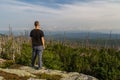 Young man tourist standing on top of mountain, Sumava National Park and Bavarian Forest, Czech republic and Germany Royalty Free Stock Photo