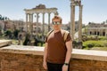 Young man tourist in sunglasses resting at Roman Forum. Historical imperial Foro Romano from panoramic point of view Royalty Free Stock Photo