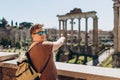 Young man tourist in sunglasses resting at Roman Forum. Historical imperial Foro Romano from panoramic point of view Royalty Free Stock Photo