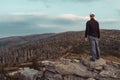 Young man tourist in white cap standing and looking to dead trees in landscape, Sumava National Park and Bavarian Forest, Czech