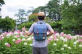 Young man tourists backpack are standing thumbs up for great performances. at spider flower garden. during traveling in the Royalty Free Stock Photo