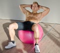 Young man training abs on fitness ball Royalty Free Stock Photo