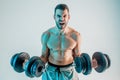 Young man training biceps muscles with dumbbells Royalty Free Stock Photo