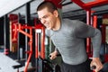 A young man trains in the gym, shakes on the gym triceps and bic