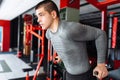 A young man trains in the gym, shakes on the gym triceps and bic