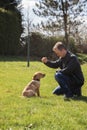 A young man trains a labrador retriever puppy at home. Animal friendship and care