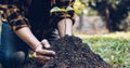 Young man transplanted small seedlings into mineral rich potting soil and prepared to water the plants, Plants help increase oxyge