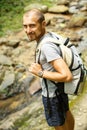 Young man with a travel backpack near a waterfall in Thailand Royalty Free Stock Photo