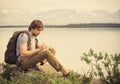 Young Man Traveler with backpack reading book Royalty Free Stock Photo