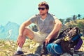 Young Man Traveler with backpack relaxing on Mountain summit rocky cliff with aerial view of Sea Royalty Free Stock Photo