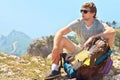 Young Man Traveler with backpack relaxing on Mountain summit rocky cliff with aerial view of Sea Royalty Free Stock Photo