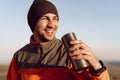 Young man traveler drinking from his thermocup while halt on a hike Royalty Free Stock Photo