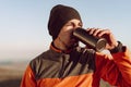 Young man traveler drinking from his thermocup while halt on a hike Royalty Free Stock Photo