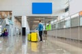 Young man traveler with suitcases at airport behind flight timetable. Man with bag and yellow suitcase luggage travel Royalty Free Stock Photo