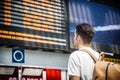 Young man traveling, reading train timetable in railway station Royalty Free Stock Photo