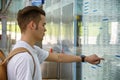 Young man traveling, reading train timetable in railway station Royalty Free Stock Photo