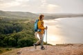 young man trekking on mountains having relaxing break, holding hiking poles Royalty Free Stock Photo