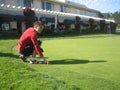 A young man tries to dense lawn grass on the golf