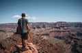 Young man trousist standing in front of Grand Canyon. Hiker with backpack enjoying view, USA. Travel and outdoort Royalty Free Stock Photo