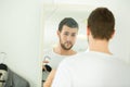 Young man trying shirt on in front mirror Royalty Free Stock Photo