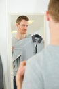 young man trying shirt in front mirror Royalty Free Stock Photo