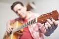 Young man tuning a guitar at home, detail shot with selective focus Royalty Free Stock Photo