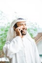 man in a turban is calling using a mobile phone while smiling