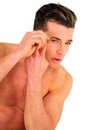 Young man tweezing eyebrows Royalty Free Stock Photo