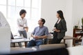 Young man and two female colleagues talking in an office