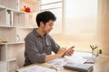 Young man typing chat or message on mobile phone with smiling face Royalty Free Stock Photo