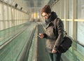 Young man typing SMS standing in the subway Royalty Free Stock Photo