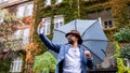 Young man with umbrella making video outdoors on street, social media concept.