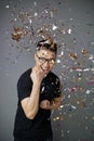 Young man under falling confetti