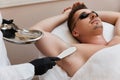 young man undergoes procedure of arm pit laser epilation Royalty Free Stock Photo