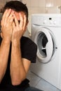 Young man unhappy with washing mashine Royalty Free Stock Photo