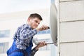 Man Fitting TV Satellite Dish On Wall Royalty Free Stock Photo