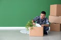 Young man unpacking box indoors. Moving into new house Royalty Free Stock Photo