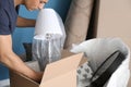 Young man unpacking box indoors. Moving into new house Royalty Free Stock Photo