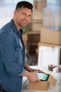 young man unpacking cardboard boxes in new apartment