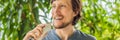 Young man uses an oral irrigator to brush his teeth BANNER, LONG FORMAT