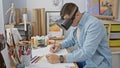 A young man uses virtual reality goggle in a creative studio setup while holding a pencil Royalty Free Stock Photo