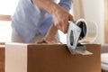 Young man using adhesive scotch, packing carton box at home. Royalty Free Stock Photo