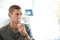 Young man using asthma machine indoors Royalty Free Stock Photo